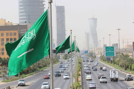 علم السعودية وشارع وسيارات